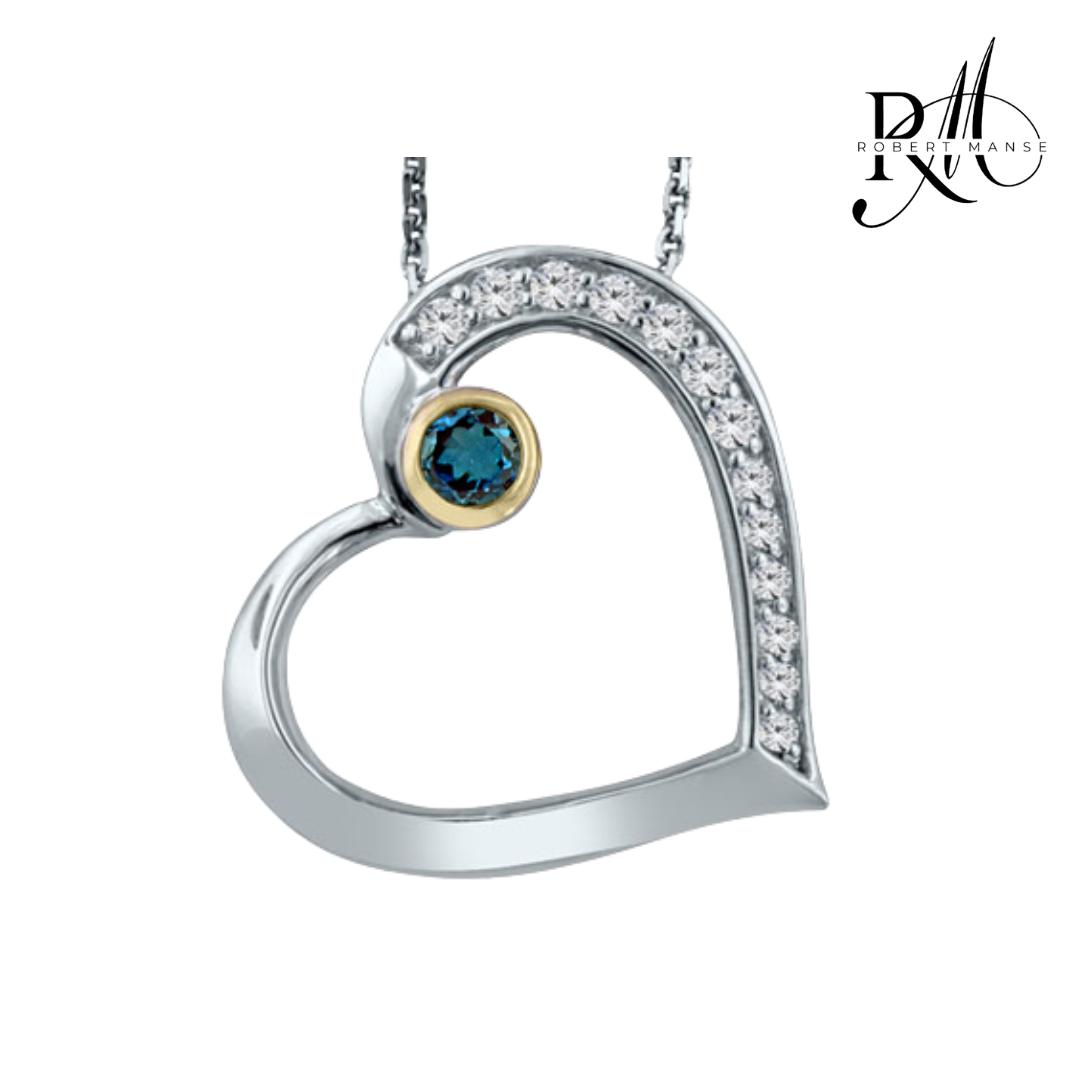A sterling silver heart-shaped necklace pendant featuring a central London Blue Topaz round gemstone, surrounded by smaller white zircon round stones, attached to a chain.