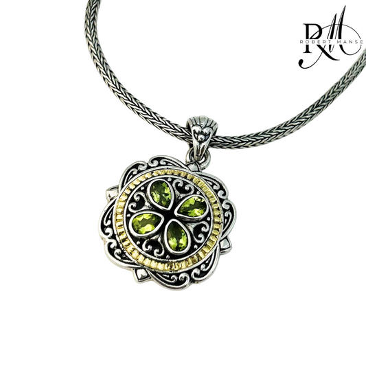 Silver pendant with green gemstones on a white background